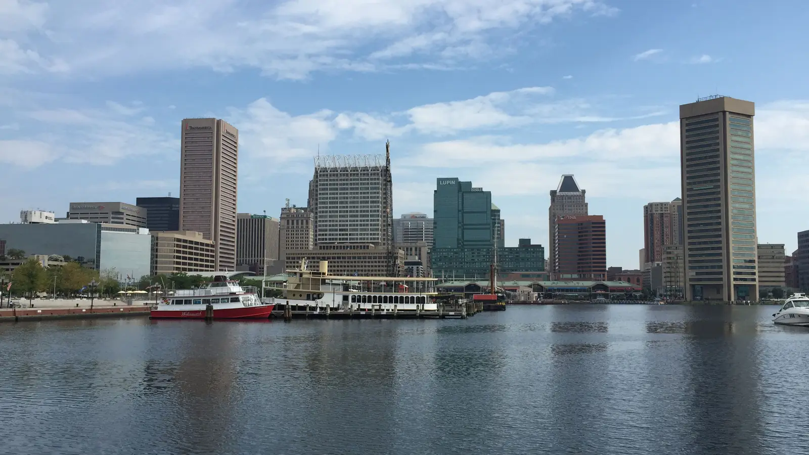 Downtown Baltimore across the calm water of the Inner Harbor in morning light.