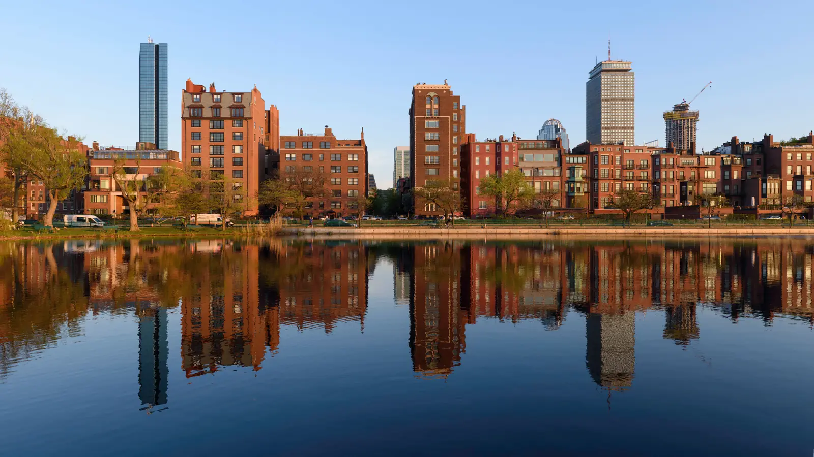 Back Bay brownstones, 200 Clarendon and the Prudential Tower reflected in the still water of Storrow Lagoon on Boston's Charles River Esplanade.