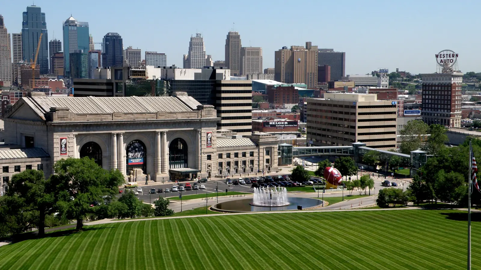 Kansas City Union Station and the downtown skyline above a striped lawn.