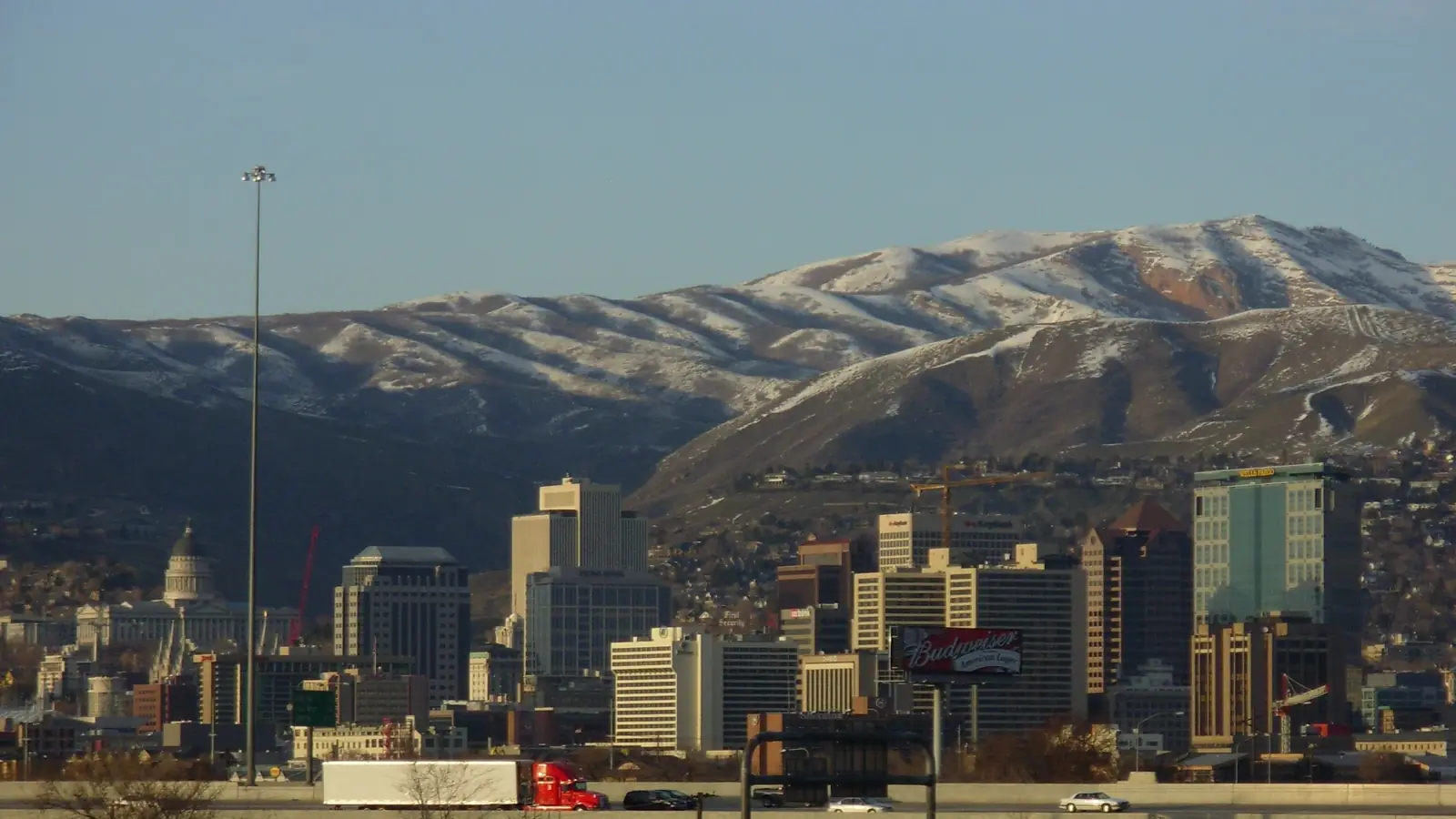 Downtown Salt Lake City and the Utah State Capitol beneath the snow-dusted Wasatch foothills.